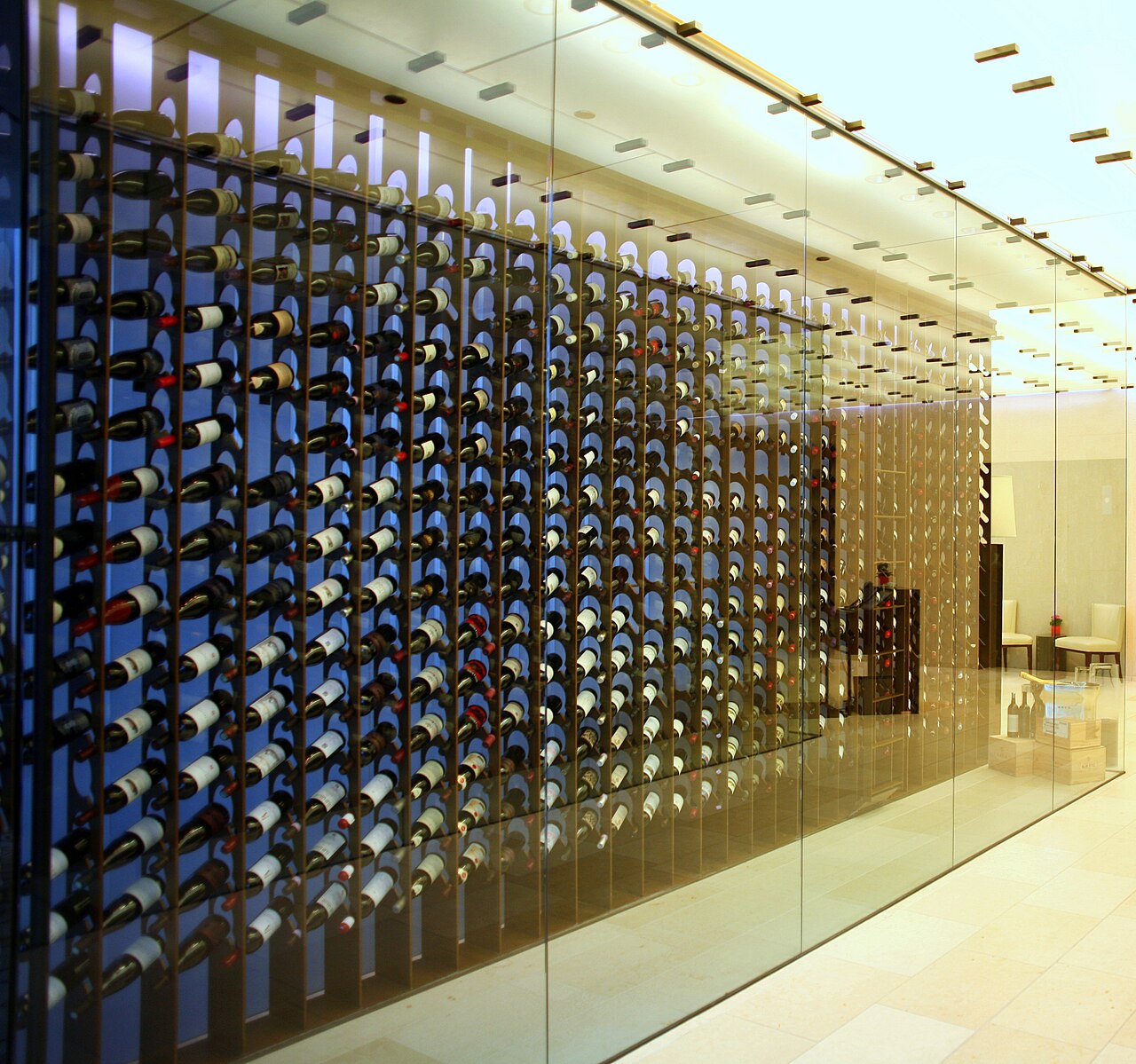 Floor to ceiling contemporary wine display showcase behind glass